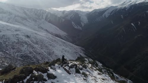 Man Standing on Snowy Hill and Mountains Forests.