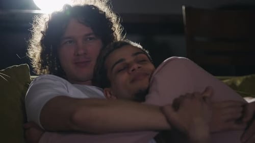 Loving Couple Embracing on Sofa in Warmly Lit Home