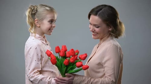 Loving Girl Gives Flowers to Woman