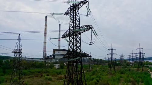 Electricity pylons and high-voltage power lines on the green grass.