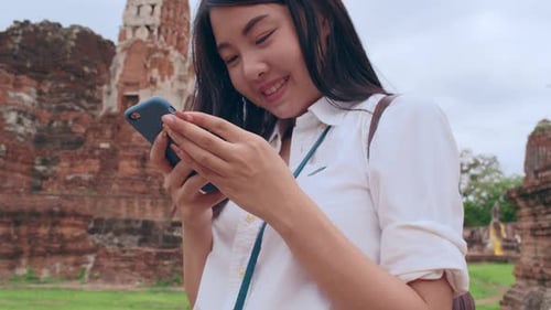 Woman with Smartphone at Ancient Temple Ruins