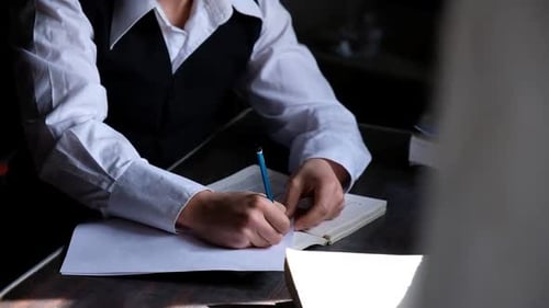 Person Writing in Notebook Indoors in Daylight