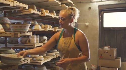 Smiling Female Pottery Artist Showing Brown Clay Bowl to the Camera