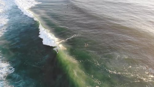 Surfers Riding Ocean Waves From Aerial View