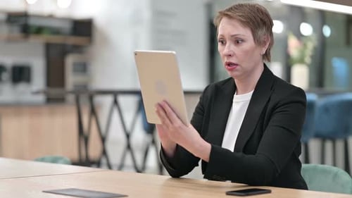 Woman Working With Tablet Device in Business Setting