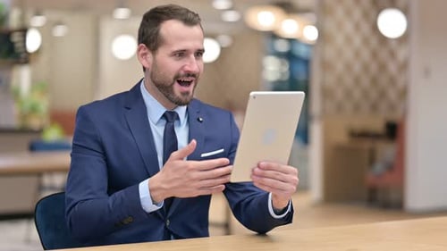 Man in Suit Celebrates Good News on Tablet