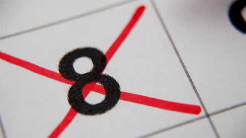 El octavo número del calendario está tachado con una cruz roja en una macro en una hoja blanca