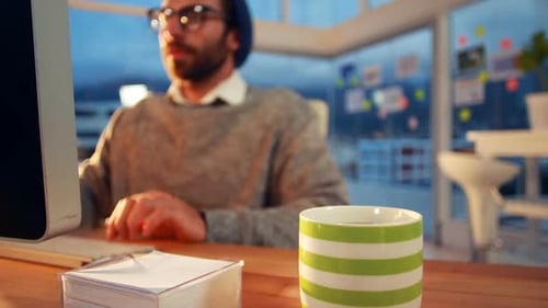Geschäftsführer arbeitet beim Kaffeetrinken am Computer