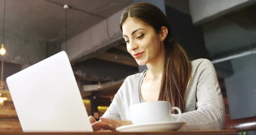 Woman using laptop in cafe