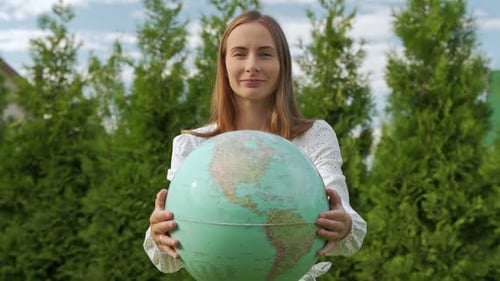 Woman Holding Globe in Natural Green Setting
