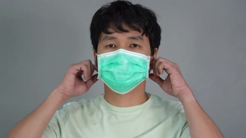 man removes a medical mask (surgical mask) and smiling