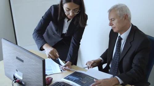 Focused Female Project Manager Explaining Document Details