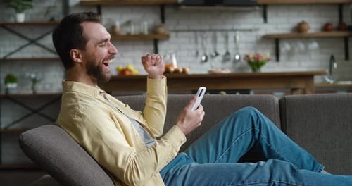 Man Relaxing on Sofa using Smartphone
