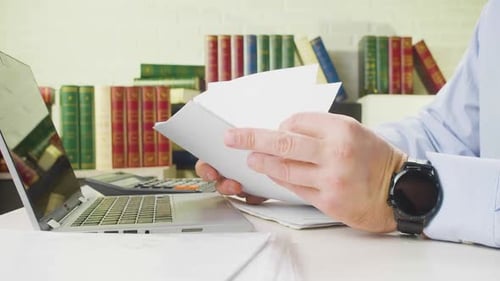 Male Hands with Documents Closeup a Man at the Workplace in the Office Checks Documents