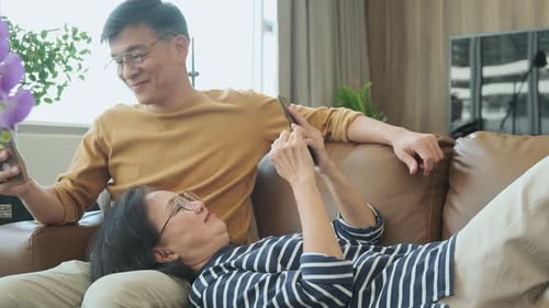 Couple Relaxing at Home Using Smartphones