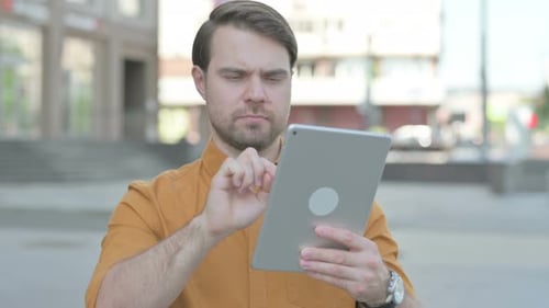 Portrait of Young Man using Digital Tablet Outdoor