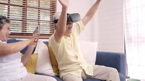 Excited Senior Man Using VR Headset on Couch