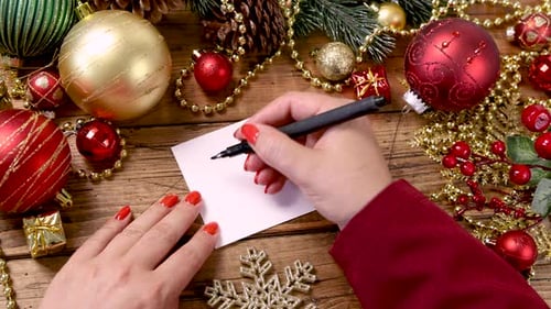 Overhead of Christmas Decorations with Hands Writing