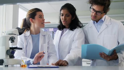 Científicos con microscopio trabajando en laboratorio