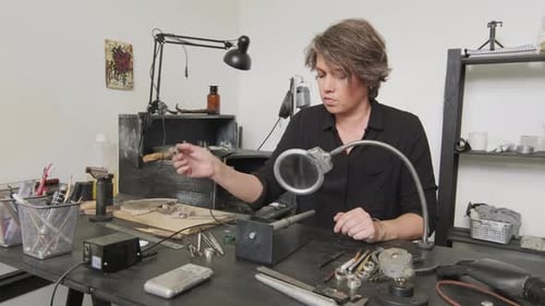 Woman Using Soldering Iron on Handmade Ring