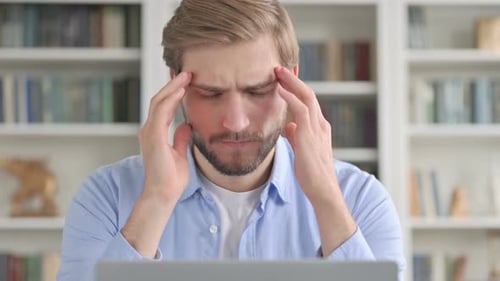 Adult Massaging Temples at Laptop Due to Headache