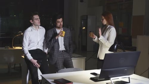 Young Caucasian Male and Female Colleagues Drink Coffee in the Office During a Break