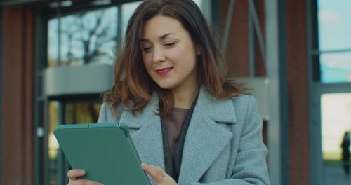 Beautiful Young Businesswoman with Tablet Computer Outside the Office Building