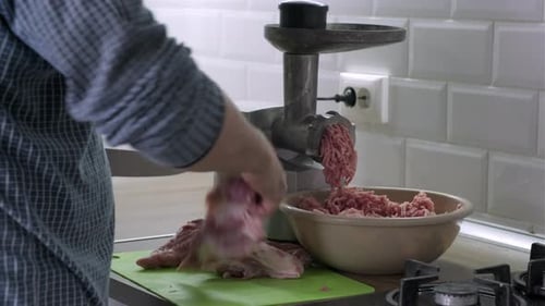 Mans Hands Cut Raw Meat with the Knife in the Kitchen