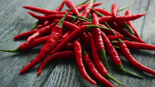 Pile of Fresh Red Chili Peppers on Wood