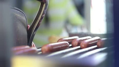 Hot Dogs Cooking on a Metal Grill