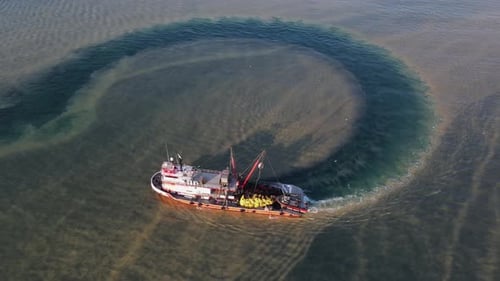 Fishing Boat Circles Murky Ocean Waters From Above