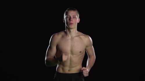 Shirtless Man Running on a Black Background