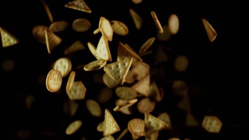 Assorted Golden Brown Crackers Falling on Black