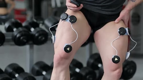 Man Uses EMS Device on Upper Leg Muscles
