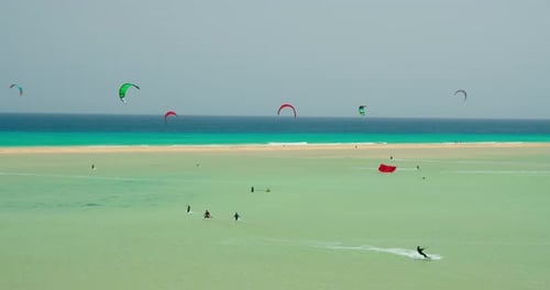 Group of Kite Surfer Kiteboarding on Waves of Atlantic Ocean in Playa Esmeralda Fuerteventura Canary
