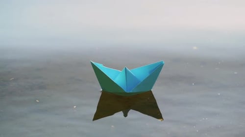 Paper Boat Floating on Water
