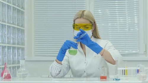 Woman Mixing Liquids in Lab Experiment