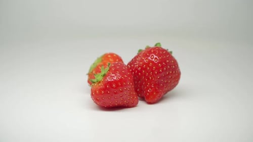 Three Delicious Red Strawberries At The Top Of The Table - Close Up Shot