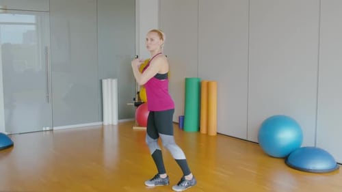 Side View Wide Shot of Fitness Trainer Raising Leg and Talking. Portrait of Confident Professional