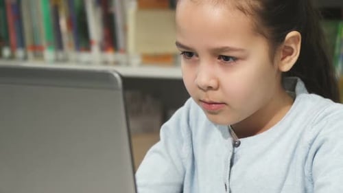 Girl Studying with Laptop in School Library