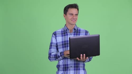 Young Adult Typing on Laptop in Front of Greenscreen
