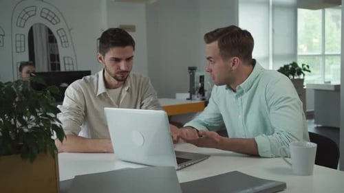 Deux jeunes hommes d'affaires heureux travaillant ensemble dans le bureau
