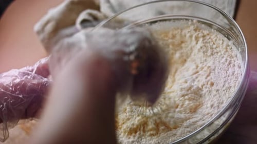 Hands Mixing Batter with Whisk in Glass Bowl