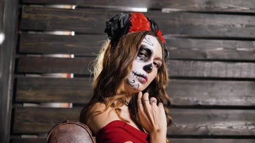 Portrait of a Woman with a Bright Halloween Makeup on the Floor of Her Face Posing in the Studio