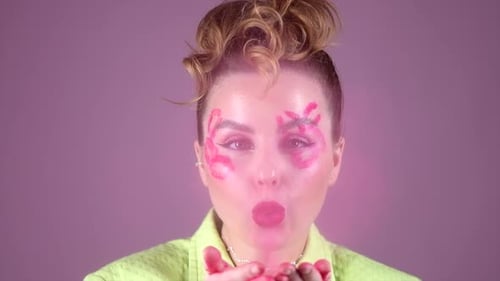 Woman with Pink Makeup Blowing Glitter