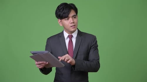 Young Adult Using Tablet in Front of Green Screen
