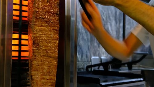 Chef Prepares Gyro Meat Slices in Restaurant