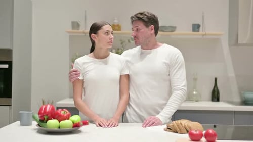 Woman and Man Embrace in Kitchen