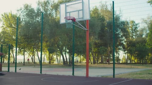 Joueur de basket noir suspendu à un cerceau à l'extérieur