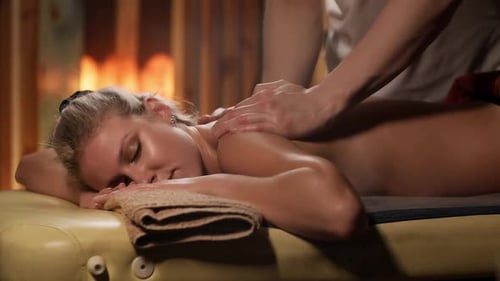 Masseur massiert junge blonde Frau im Spa Center